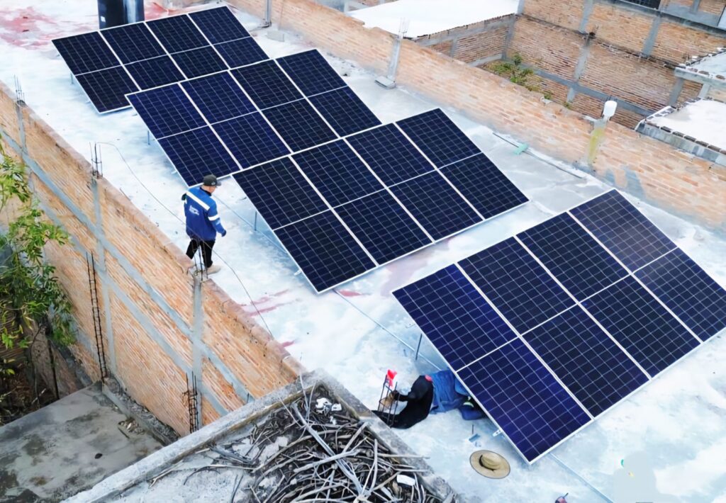 Technicians installing a rooftop photovoltaic solar panel system for a residential property as part of a clean energy project.
